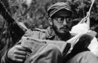 Fidel reading newspaper in mountains